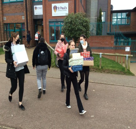 Students carrying shoeboxes for Winter Night Shelter MK