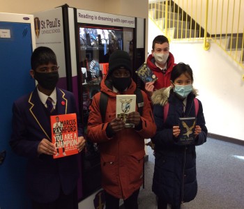 Students with their chosen books from the vending machine