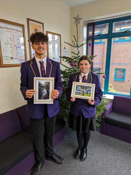 Students holding their winning photography competition entries