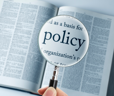 Book with magnifying glass over the word policy